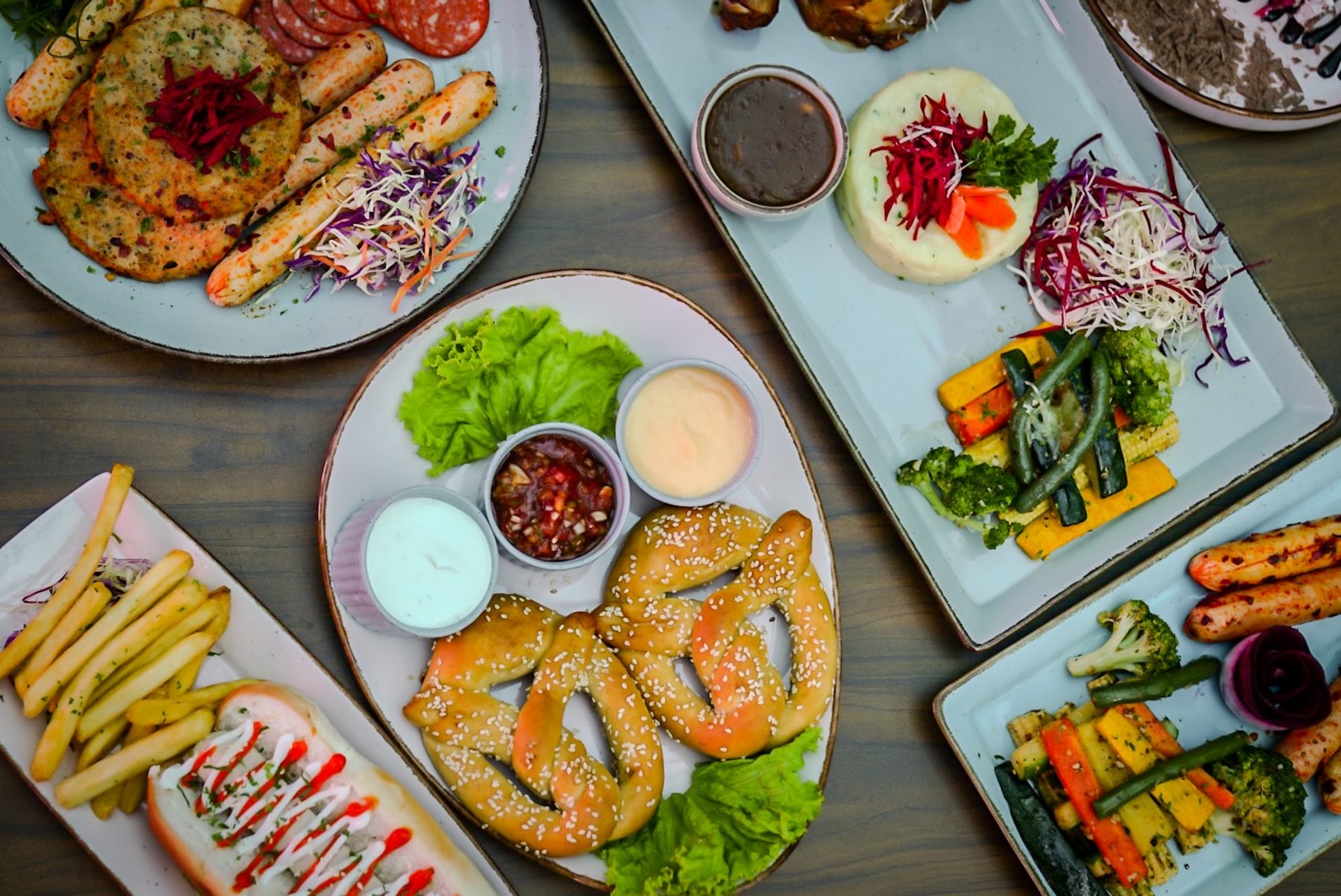 Overhead spread of pretzels, sausage platters, fries and dips at Bier Loft