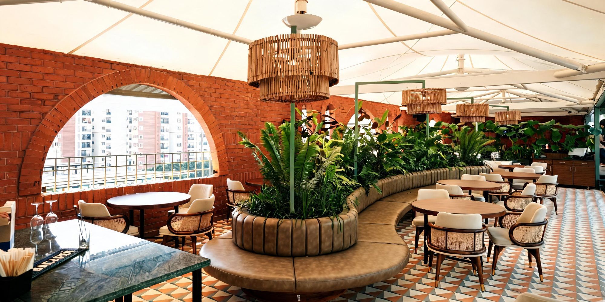 Covered rooftop terrace lounge at Bier Loft with curved banquette seating and plants